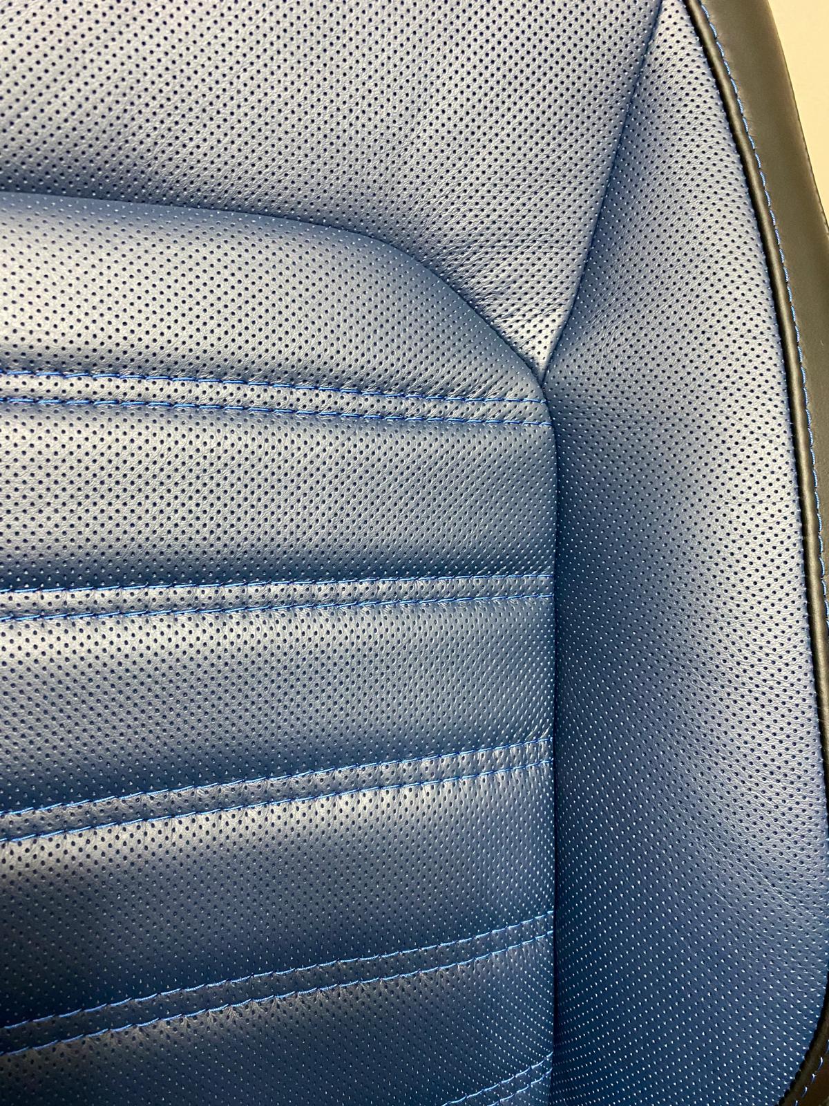 New Defender seat close-up of perforated blue leather centre panel with detailed stitching.